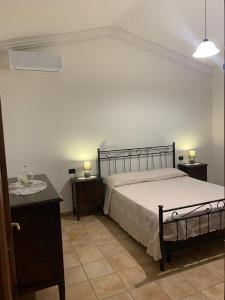 a bedroom with a bed with two night stands and two lamps at VILLA LUPINO in Orosei