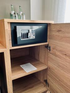 a microwave in a wooden cabinet with a tv at Hotel-Restaurant Zum Schwanen in Wermelskirchen