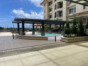 a pavilion with a pool in front of a building at J&SM Riverine resort homestay in Kuching