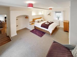 a bedroom with a large bed and a purple rug at The Brew House in Tideswell