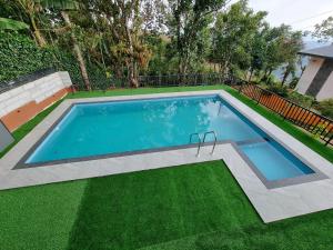 a swimming pool in a yard with green grass at Peakaavu Cottages in Idukki