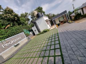 a brick driveway withgrass in front of a house at Peakaavu Cottages in Idukki