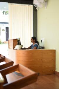 a woman sitting at a desk in an office at Peakaavu Cottages in Idukki