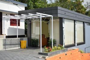 a black and white house with a pergola at Peakaavu Cottages in Idukki