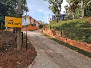 a yellow sign on the side of a dirt road at Peakaavu Cottages in Idukki