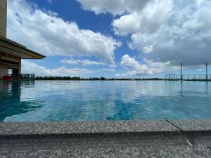 a pool of water with a blue sky and clouds at J&SM Riverine resort homestay in Kuching