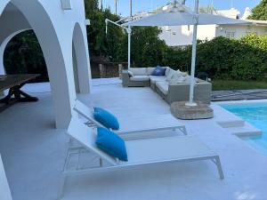 patio con divano e ombrellone accanto alla piscina di Villa a Rosa Marina con piscina a 300 m. dal mare a Rosa Marina