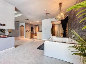 a large kitchen with a white island and a chandelier at Key View - Hub Canal 1 in Dubai