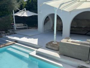 una piscina con ombrellone bianco e tavolo di Villa a Rosa Marina con piscina a 300 m. dal mare a Rosa Marina
