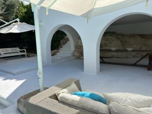 patio con divano e ombrellone di Villa a Rosa Marina con piscina a 300 m. dal mare a Rosa Marina