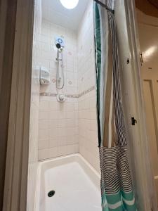 a bathroom with a tub and a shower at LiveStay Room with Free Parking in Wembley in London