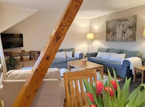 sala de estar con sofá azul y TV en Ferienwohnung Am Speicher, en Wietzendorf