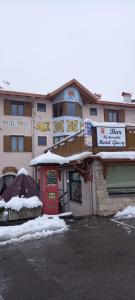 a building with a restaurant with snow on the ground at Hotel Giusy in Malosco