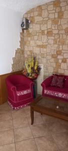 a living room with two purple chairs and a table at Hotel Giusy in Malosco