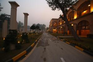 una strada vuota con un edificio e un albero di Peshawar Barracks a Peshawar