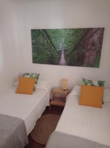 Zimmer mit 2 Betten und Wandgemälde in der Unterkunft Casa en la playa, Aldea Coast in San Nicolás