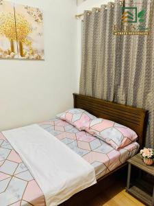 - une chambre dotée d'un lit avec des draps roses et blancs dans l'établissement Trees Residences Staycation 1br/2br, à Manille