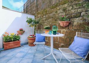 Una mesa y sillas en un patio con plantas. en Maison Villa Angela, en SantʼAgata sui Due Golfi