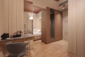 ein Zimmer mit einem Schlafzimmer mit einem Bett und einem Stuhl in der Unterkunft Zenith Premium Suites in Thessaloniki