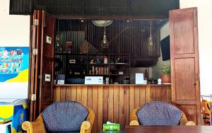 塔林甘海灘的住宿－Aforetime House @ Samui，一间带两把椅子的餐厅和一间酒吧