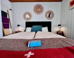 um livro em cima de uma cama com espelhos em Hôtel Restaurant Les Cernets Swiss-Lodge SSH em Les Verrières