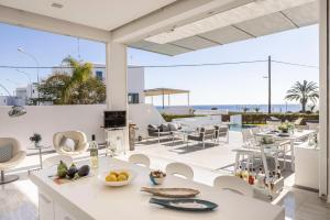an open kitchen and living room with a view of the ocean at Protaras Elaia Luxury Seafront Villa in Protaras
