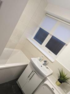 een badkamer met een wastafel, een toilet en een raam bij Above us only sky in Kirkby