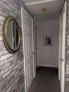 um corredor com um espelho e uma parede de tijolos em Above us only sky em Kirkby