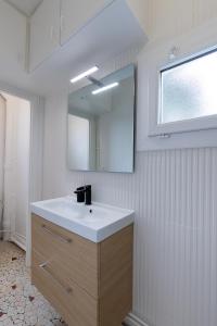 a bathroom with a white sink and a mirror at Smart Inn Fontainebleau Centre- Appartement 1 chambre in Fontainebleau