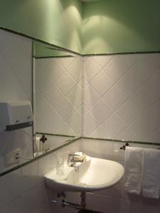 a bathroom with a sink and a mirror at Hotel Plateros in Córdoba