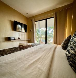 a bedroom with a large bed with a large window at Southseas Beach Resort and Dive Center in Santander