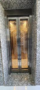 a metal elevator in a building with windows at The Host in Amritsar