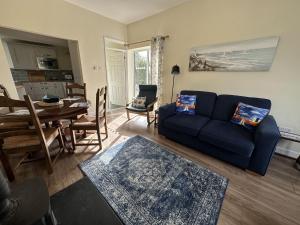 uma sala de estar com um sofá azul e uma mesa em Immaculate 2 bedroom bungalow close to beaches em Pendine