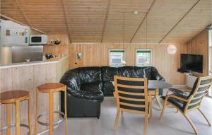 SpodsbjergにあるLovely Home In Rudkbing With Wifiのリビングルーム(革張りのソファ、テーブル、椅子付)