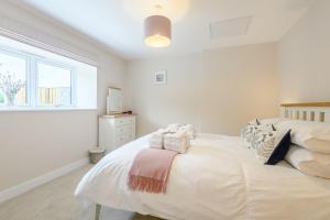 a white bedroom with a bed with towels on it at Butterfly in Boston