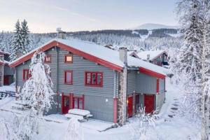 a house with red doors in the snow at Fritidsleilighet i Vikinggrenda in Trysil