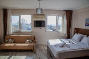 a bedroom with a bed and a couch and windows at City Hall Apart Hotel Sultanahmet in Istanbul