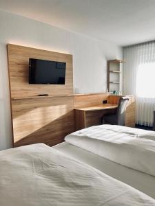 a hotel room with two beds and a flat screen tv at Hotel-Restaurant Zum Schwanen in Wermelskirchen