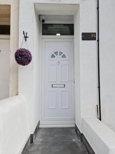 uma porta branca com um cesto de flores roxas em SureBillionaire Home Deluxe Queen Studio em Londres