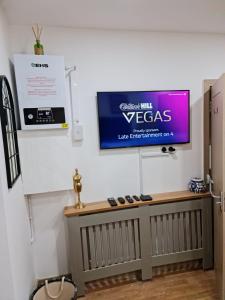 uma televisão pendurada numa parede num quarto em SureBillionaire Home Deluxe Queen Studio em Londres