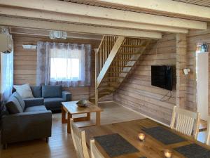 a living room with a couch and a staircase at Fishing and holiday village Merikoivula in Uusikaupunki