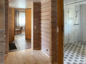 a bathroom with a wooden wall with a shower at Fishing and holiday village Merikoivula in Uusikaupunki