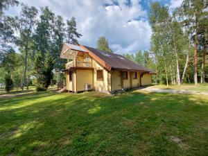 a house in the middle of a grass field at Fishing and holiday village Merikoivula in Uusikaupunki