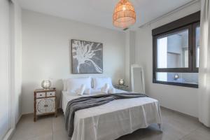 une chambre blanche avec un lit et une fenêtre dans l'établissement Ocean Homes by Ĥ - Playa de los Haraganes HOHH7104P70, à Isla Canela 44 autres photos