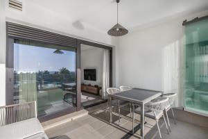 une salle à manger avec une table et des chaises sur un balcon dans l'établissement Ocean Homes by Ĥ - Playa de los Haraganes HOHH7104P70, à Isla Canela