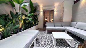 uma sala de estar com sofás e plantas na parede em PINACOTA SUITES ATHENS em Atenas
