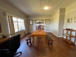a dining room with a wooden table and chairs at Sugar Farm House in Pietermaritzburg