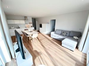uma sala de estar com uma mesa e um sofá em Seeliebe Apartments Schwerin - am See, Seeblick, PKW, Sauna, XXL-Balkon, Terrasse, modern em Schwerin