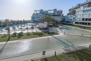 una gran masa de agua con palmeras y edificios en Ocean Homes by Ĥ - Playa de los Haraganes HOHH7104P70, en Isla Canela