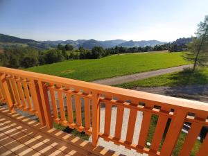 eine Holzterrasse mit Blick auf ein grünes Feld in der Unterkunft Landhaus am Schindelberglift in Oberstaufen